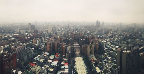 Cityscape against sky in foggy weather