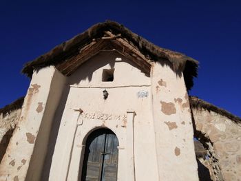 Low angle view of old building against blue sky