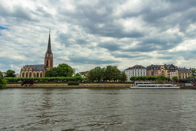 River in city against cloudy sky