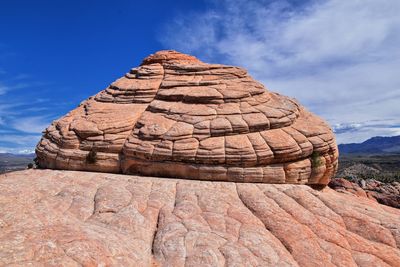 Rock formation against cloudy sky