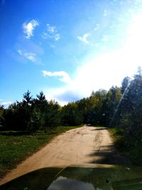 Road by trees against sky