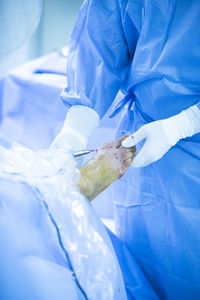 Midsection of surgeon operating patient at hospital