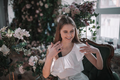 Portrait of smiling young woman holding plant