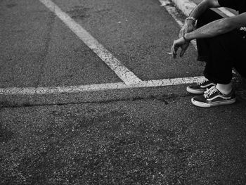 Low section of man standing on road