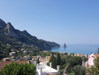 Townscape by sea against clear blue sky