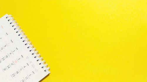 High angle view of white paper against yellow background