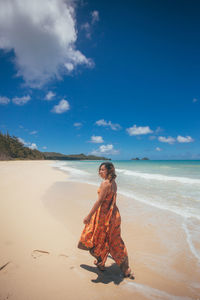 Full length of woman on beach against sky