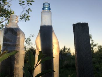 Low angle view of glass bottle against sky