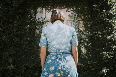 Rear view of young woman standing at doorway