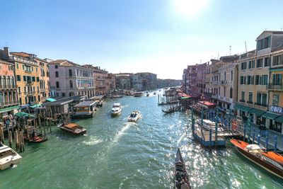 Boats in canal amidst buildings in city