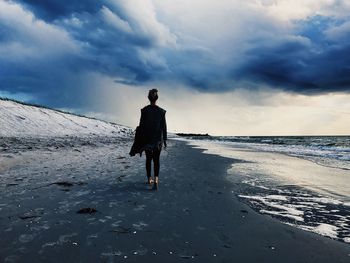 Rear view of man walking on beach