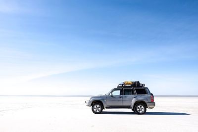 Vintage car on beach against sky