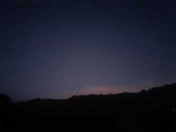 Silhouette landscape against clear sky at night