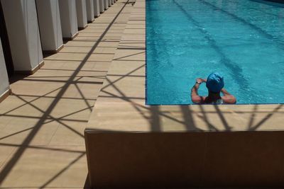 Rear view of man resting in swimming pool