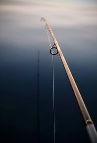 Close-up of fishing rod on wooden post