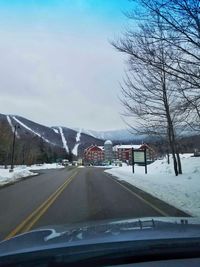 Cars on road against sky seen through car windshield