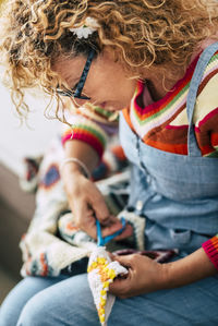 Midsection of woman holding while sitting outdoors