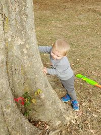 High angle view of boy standing by tree in park