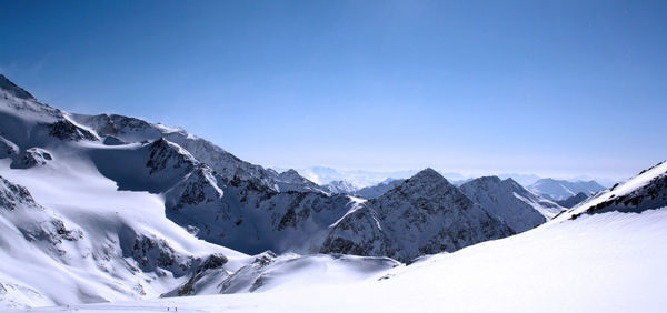 Scenic view of snowcapped mountains against clear blue sky
