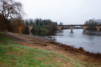 Arch bridge over river against sky