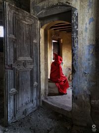 Rear view of woman standing at entrance of building