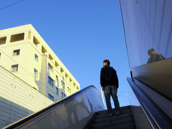 Low angle view of man standing against building