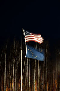 Illuminated flag against sky at night