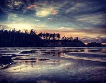 View of frozen lake against cloudy sky during sunset