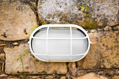 High angle view of sunglasses on rock against wall