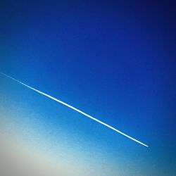 Low angle view of vapor trail in blue sky