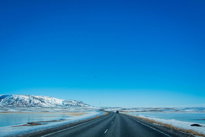 Road against clear blue sky