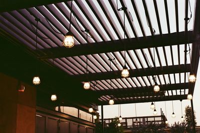 Low angle view of illuminated lighting equipment hanging on ceiling