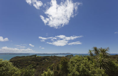 Scenic view of sea and landscape against blue sky