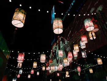 Low angle view of illuminated lighting equipment at night