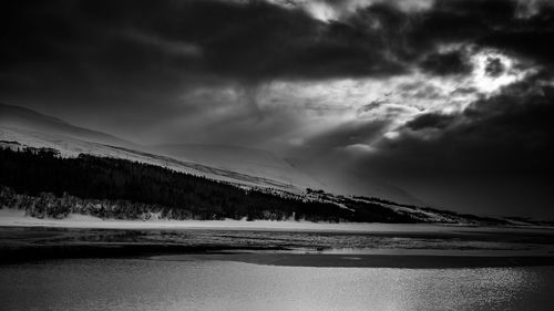 Scenic view of snow covered mountain against cloudy sky