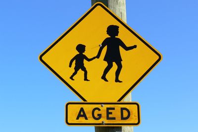 Low angle view of road sign against clear sky