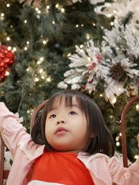 Portrait of girl looking at christmas tree