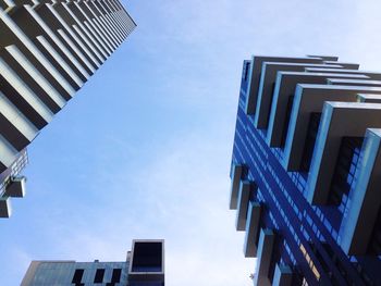 Low angle view of office building against blue sky