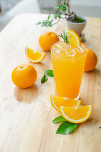 Fresh orange juice in the glass on wooden table