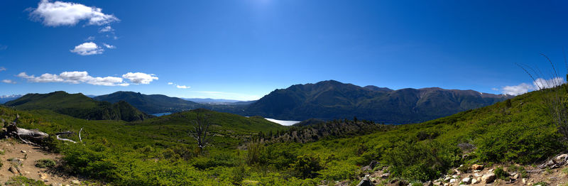 Scenic view of landscape and mountains against blue sky