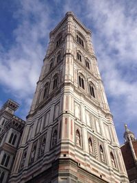 Low angle view of clock tower against cloudy sky