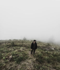 Man standing on field against sky