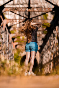 Rear view of woman standing against trees