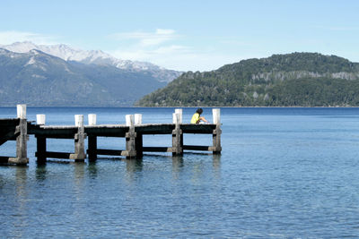 Wooden pier in lake against sky