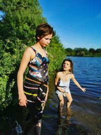 Full length of mother and daughter in lake