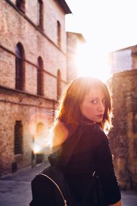 Portrait of woman standing against snow during sunset