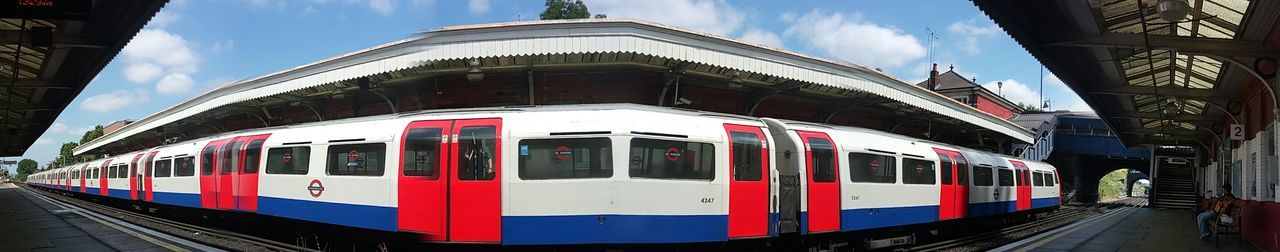 Train at railroad station in city against sky