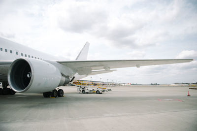 Airplane on airport runway against sky