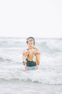 Portrait of boy playing with ball at beach