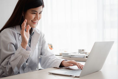 Young woman using phone on table